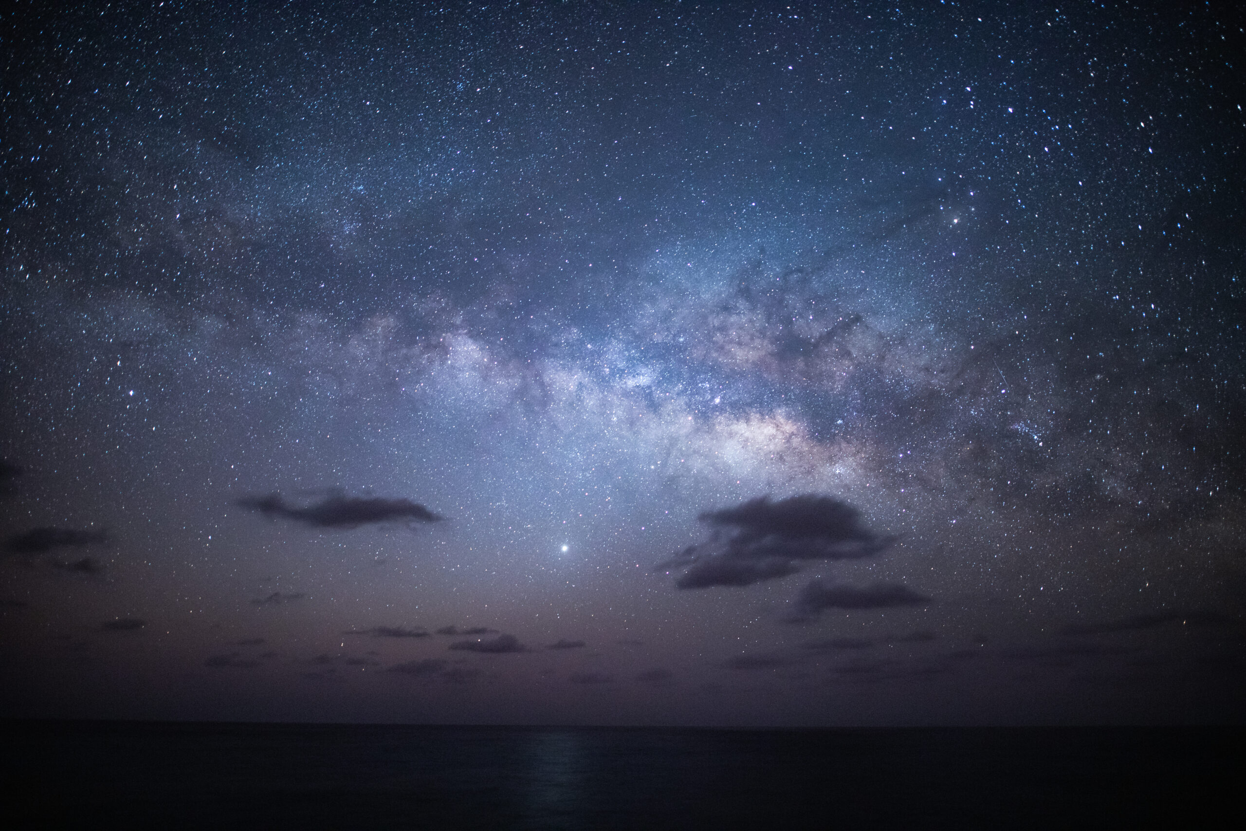 宮古島の夜空に広がる満天の星空と天の川、手前には車のシルエット