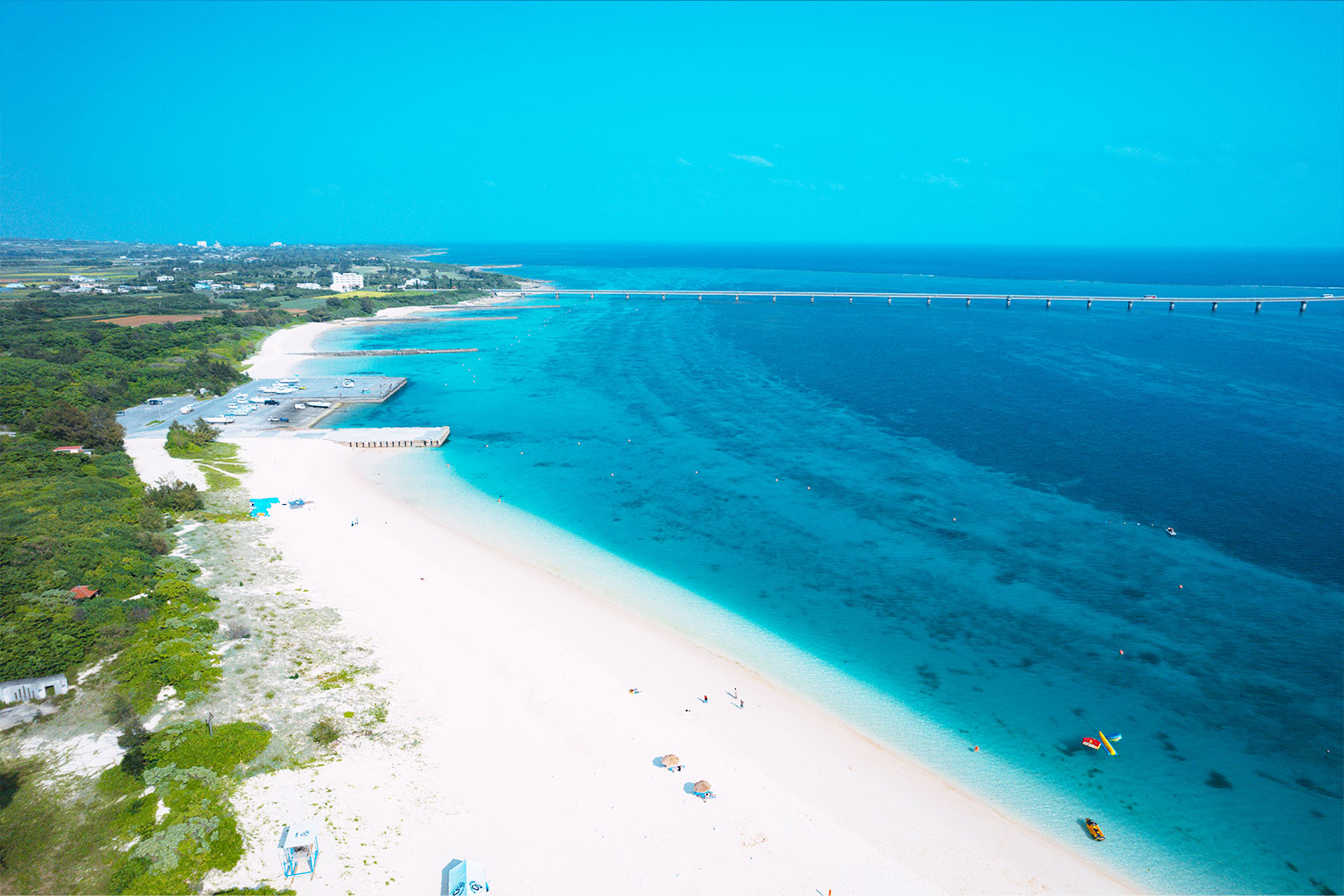 白い砂浜と青い海から昇る朝日の美しい景色
